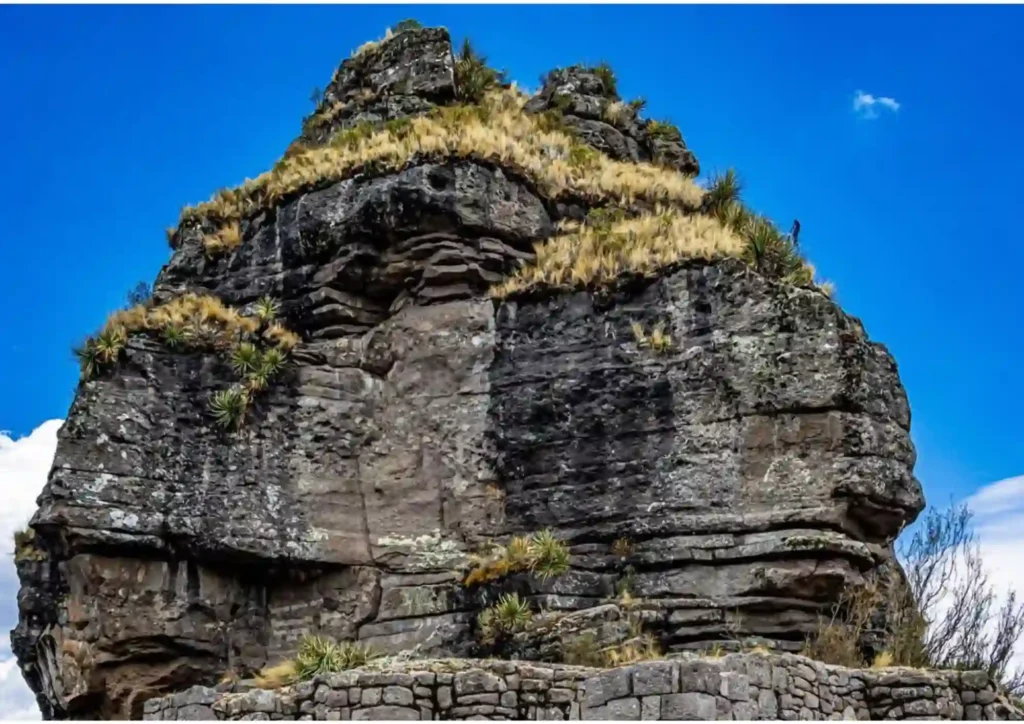 Imponente formación rocosa y muros de piedra inca de la fortaleza de Waqrapukara en Cusco.